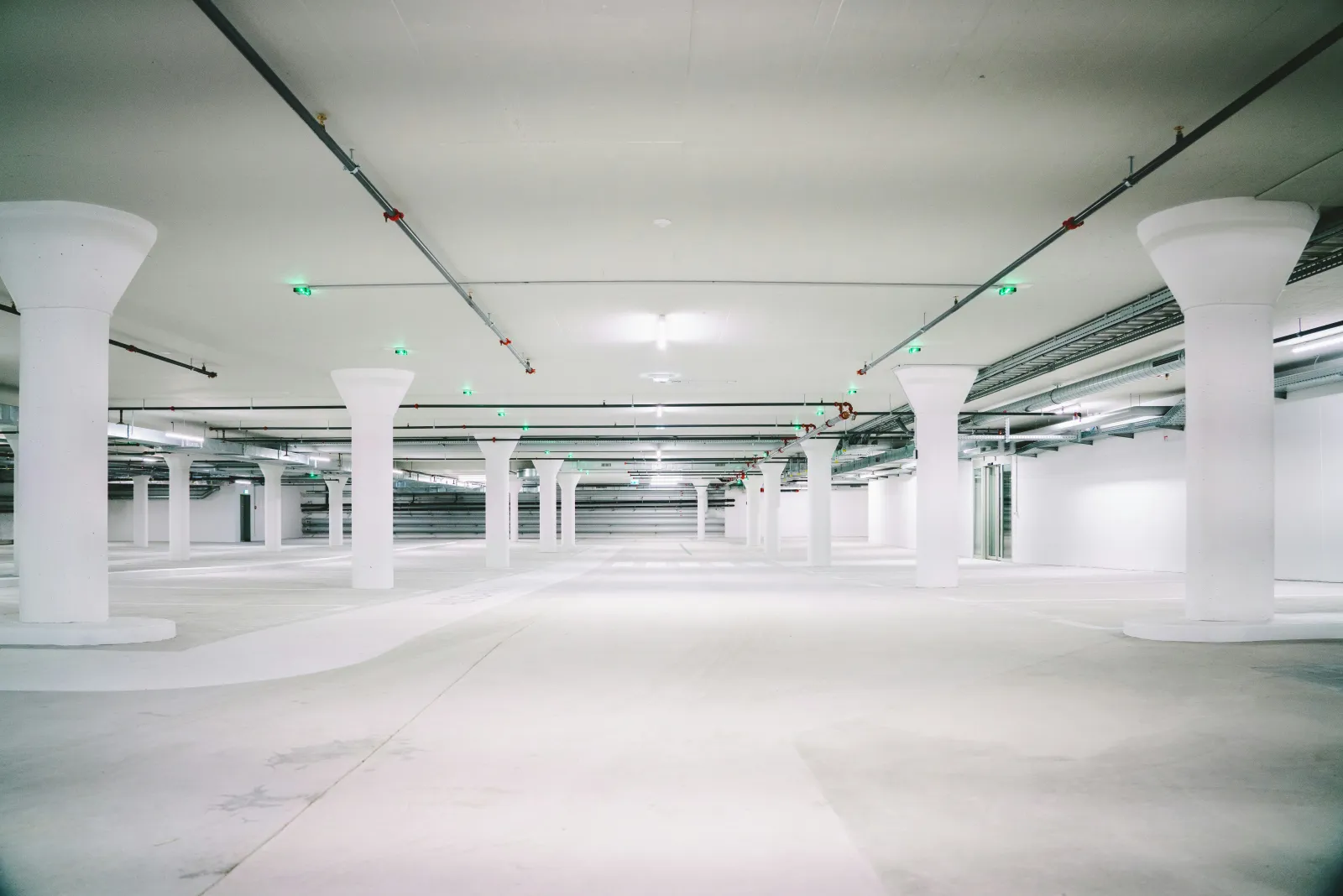 Helle, frisch gereinigte Tiefgarage mit weißen Betonstützen